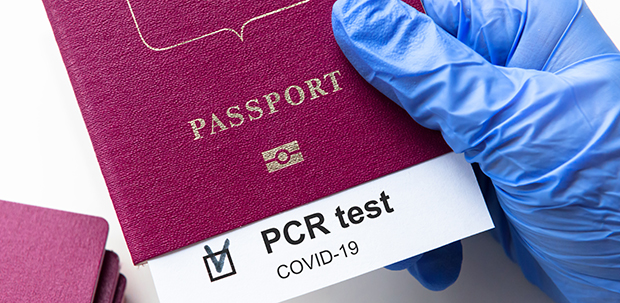 COVID-19 and travel concept, mark of coronavirus PCR testing in tourist passport. Diagnostics of coronavirus in airport due to lockdown. Business and tourism hit by corona virus during pandemic.