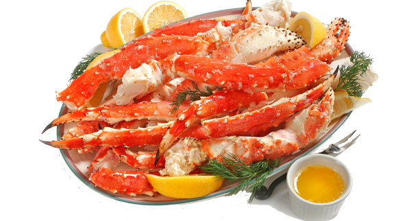 Alaskan King Crab legs on platter, served with lemon and butter, on white background